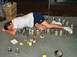 Betrunkener Mann schläft auf dem boden zwischen Bierdosen und leeren Flaschen